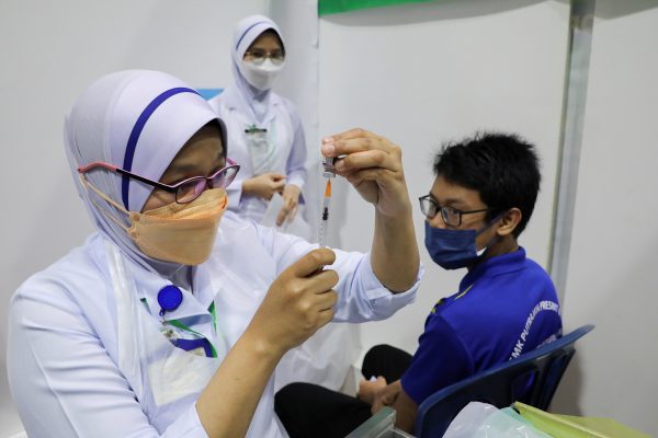 A nurse prepares a dose of the Pfizer vaccine against the coronavirus disease (COVID-19) for a secondary school student at a school, in Putrajaya, Malaysia, 20 September 2021. (Photo: Reuters/Lim Huey Teng).