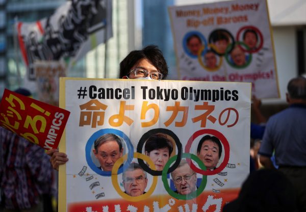 An anti-Olympics group's member displays a banner during their protest rally, amid the coronavirus disease (COVID-19) pandemic, at Shinjuku district in Tokyo, Japan 1 August 1 2021 (Photo: Reuters/Issei Kato).