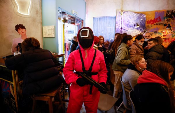 A waiter of Korean cafe Chick O'Rico poses for a picture in a costume of a personage from television series Squid Game in Moscow
