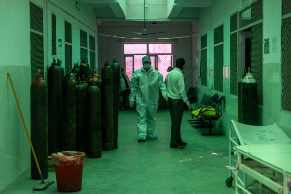 A healthcare worker walks past oxygen cylinders outside a COVID-19 intensive care unit of a government-run hospital, amidst the coronavirus disease (COVID-19) pandemic, in Bijnor district, Uttar Pradesh, India, 11 May 2021 (Photos: Danish Siddiqui, Reuters)