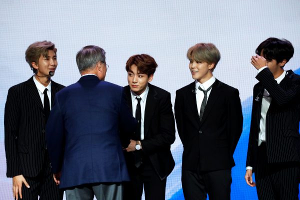President Moon Jae-in shakes hands with the members of BTS following their performance at a Korean cultural event, Paris, France, 14 October 2018 (PHOTO: Yoan Valat/Pool via REUTERS)