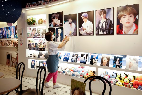 Cafe owner Kim Eun-hee wipes the dust off the picture frame in her cafe in Seoul, South Korea, 24 September 2020 (Photo: Reuters/Heo Ran).