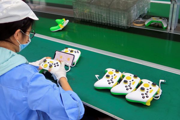 An employee works on the production line of RiotPWR mobile gaming controllers for US company T2M, at a factory in Dongguan, Guangdong province, China 7 December 2021 (Photo: Reuters/David Kirton).