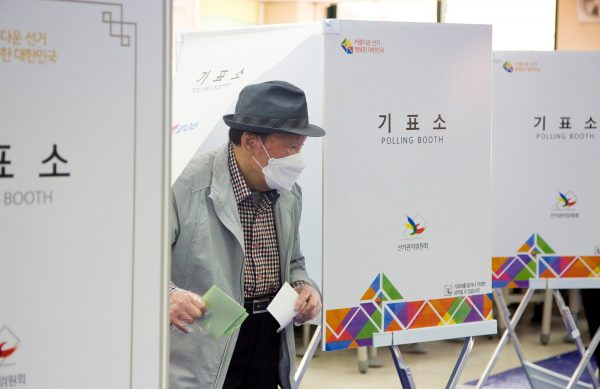 A South Korean voter casts a ballot at a polling station for the 15 April 2020 general elections in Seoul, South Korea (Photo: Lee Jae-Won/AFLO via Reuters)