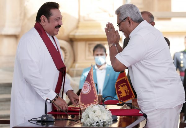 Sri Lanka's former leader Mahinda Rajapaksa and his brother, and Sri Lanka's President Gotabaya Rajapaksa gesture during the swearing in ceremony at Kelaniya Buddhist temple, Colombo, Sri Lanka, 9 August 2020. (PHOTO: REUTERS/Dinuka Liyanawatte)