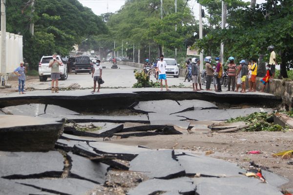 People stand near roads damaged by floods after heavy rainfall in Dili, East Timor, 5 April 2021 (REUTERS/Lirio da Fonseca via Reuters Connect).