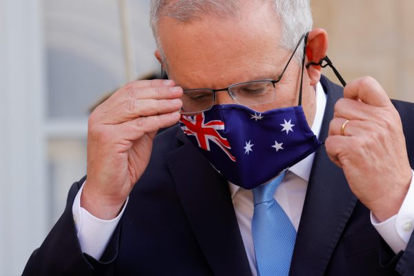 Australian Prime Minister Scott Morrison adjusts his mask during a news conference he holds with French President Emmanuel Macron in front of the Elysee Palace in Paris, France, 15 June 2021. (REUTERS/Pascal Rossignol via Reuters Connect).