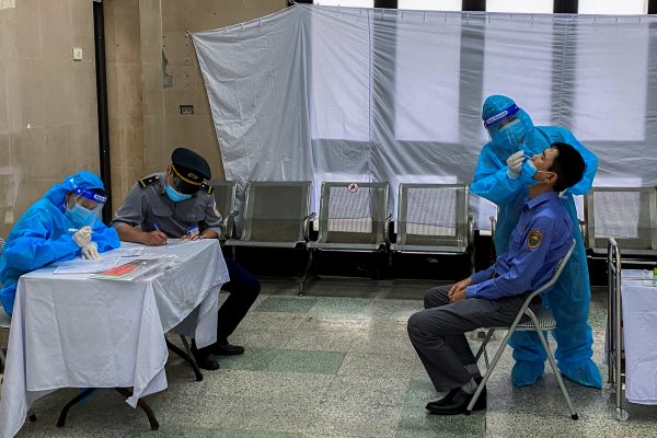 A healthcare worker takes a nasal swab sample from a worker for a coronavirus disease (COVID-19) test, at Hanoi train station in Hanoi, Vietnam, 13 October 2021 (Photo: Reuters/Nguyen Thinh Tien)