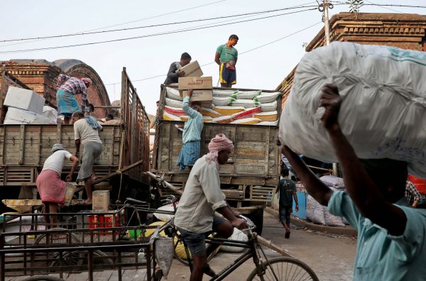 Labourers load consumer goods onto supply trucks at a wholesale market in Kolkata, India, 14 December, 2021 (Photo: Reuters/Rupak De Chowdhuri).