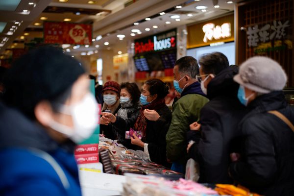 People wearing protective masks line up to buy desserts at a main shopping area, following new cases of COVID-19, Shanghai, China, 21 January 2022 (Photo: Reuters/Aly Song).