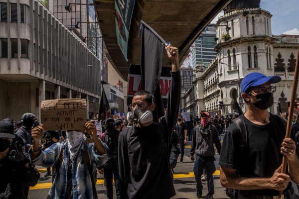 Protesters hold placards and black flag during a demonstration to demand the resignation of the then prime minister Muhyiddin Yassin, Kuala Lumpur, Malaysia, 31 July 2021 (Photo: Mohd Firdaus/NurPhoto).