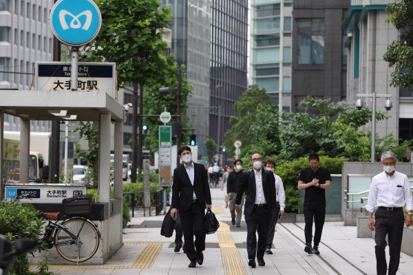 Office workers wearing face masks as a preventive measure against the spread of COVID-19 walk down a street in central Tokyo, Japan, 2 June 2021 Photo: Reuters/Stanislav Kogiku).