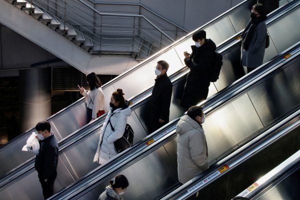 People wearing masks ride on an escalator at a subway station, amid the COVID-19 pandemic, in Seoul, South Korea, 8 December 2021 (Photo: Reauters/Heo Ran).