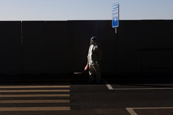 An airport employee wearing personal protective equipment (PPE) to prevent the spread of COVID-19 stands at the closed loop area of Beijing Capital International Airport after the 2022 Olympic Winter Games, Beijing, China, 21 February 2022 (PHOTO: REUTERS/Tyrone Siu)