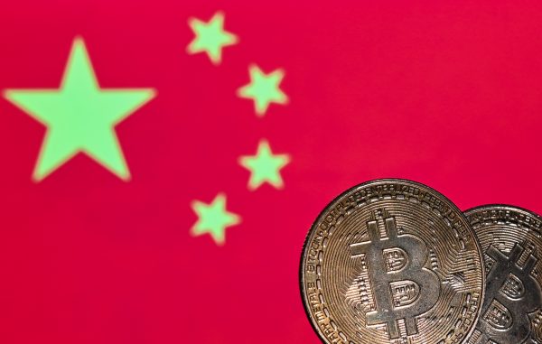 Illustrative image of two commemorative bitcoins seen in front of the national flag of China displayed on a computer screen, 9 January 2021 (Photo: Reuters/Artur Widak).