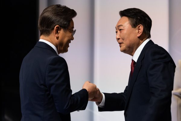 Lee Jae-myung, presidential candidate from the ruling Democratic Party, left, greets Yoon Suk-yeol, presidential candidate from the main opposition People Power Party, during a presidential debate at the SBS studio in Seoul, South Korea, 25 February 2022 (Photo: Reuters/SeongJoon Cho).
