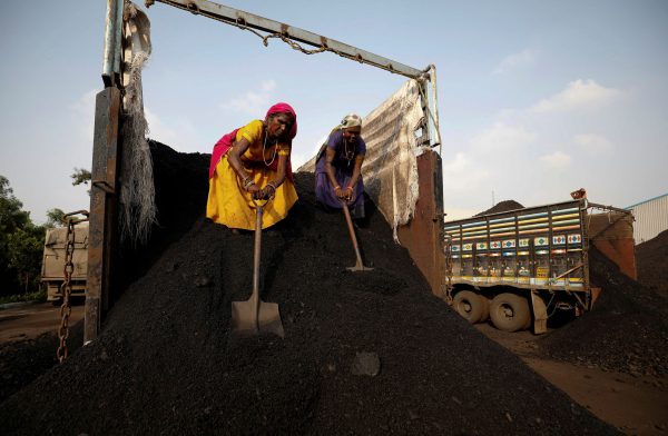 Workers unload coal from a supply truck at a yard on the outskirts of Ahmedabad, India, 12 October 2021 (Photo: Reuters/Amit Dave)