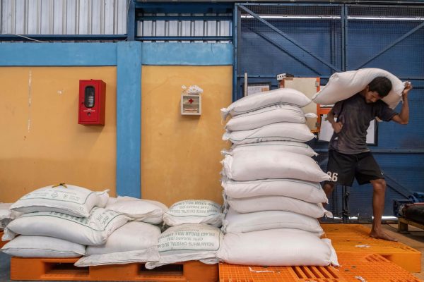 A worker lifts a sack filled with sugar after mid-March prices soared due to the impact of the Russia-Ukraine war, Kendari, Indonesia, 14 April 2022 (Photo: Reuters/Andry Denisah/SOPA Images/Sipa USA).
