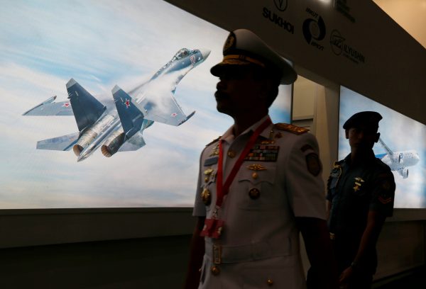 A member of Indonesia's military personnel walks past a picture of a Sukhoi jet fighter during Indo Defence Expo in Jakarta, Indonesia, 2 November 2016. (Photo: Reuters/Beawiharta).