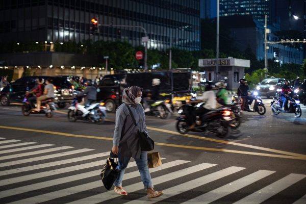 A woman crossing in the central business district of Jakarta, Indonesia, 5 November 2021 (Photo: Reuters/Afriadi Hikmal/NurPhoto).