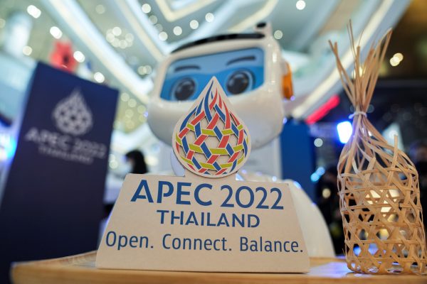 A robot holds the newly launched logo of the APEC Summit 2022 at a department store in Bangkok, Thailand, 18 November 2021 (Photo: Reuters/Athit Perawongmetha).
