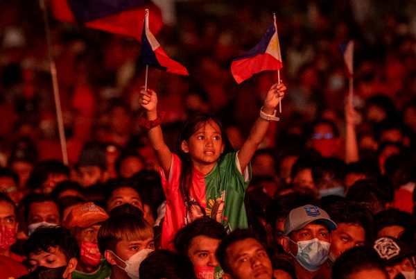 A child waves Philippine flags during the final campaign rally of presidential candidate Ferdinand 
