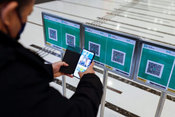 QR codes for the 'LeaveHomeSafe' COVID-19 contact-tracing app are seen outside a shopping mall at the first day of a vaccine passport roll out, Hong Kong, 24 February 2022 (Reuters/Tyrone Siu).
