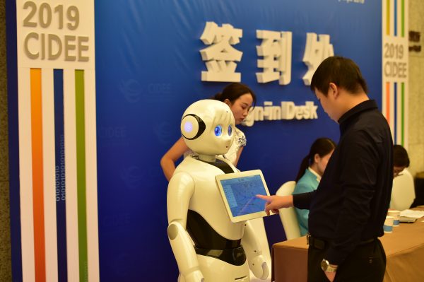 A visitor interacts with a robot by the sign-in desk at the 2019 STAR Market and Digital Economy Summit in Shijiazhuang city, Hubei province, China, 10 October 2019 (Photo: Reuters/Oriental Image).