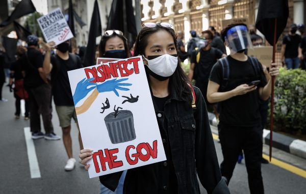 A protester holds a placard during the demonstration. Hundreds of black-clad Malaysians staged an anti-government protest near the Independence Square in Kuala Lumpur demanding the resignation of the prime minister over his handling of the coronavirus pandemic, as new cases soared in a surge that has also become a political crisis. (Photo: Wong Fok Loy/SOPA Images)