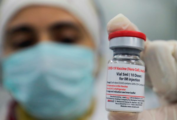 Dr Mai Osama holds a vial of China's Sinovac COVID-19 vaccine in the visual inspection unit of the Holding Company for Biological Products and Vaccines 'Vacsera' in Cairo, Egypt on 31 August 2021. (Photo: Reuters/Amr Abdallah Dalsh)