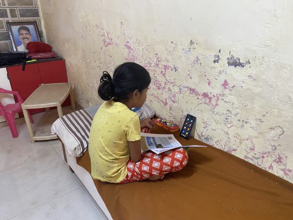 Sayi Gharat, 9, attends school online using her mother's mobile phone in Dunge village in western India, 8 February, 2022 (Photo: Thomson Reuters Foundation/Rina Chandran).