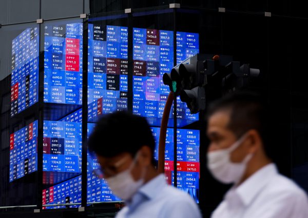 People pass by an electronic screen showing Japan's Nikkei share price index inside a conference hall, Tokyo, Japan, 14 June, 2022 (Photo: Reuters/Issei Kato).