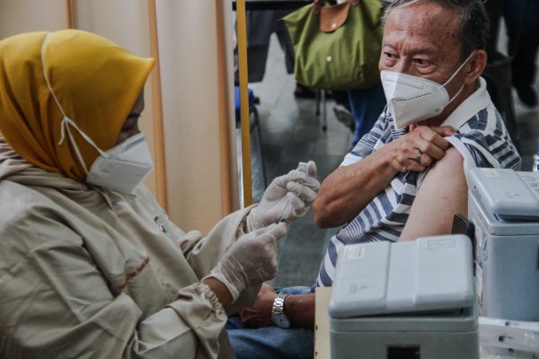 A man prepares to receive a dose of the Pfizer COVID-19 vaccine in Bandung, Indonesia, 28 July 2022 (Photo: Reuters/Algi Febri Sugita).