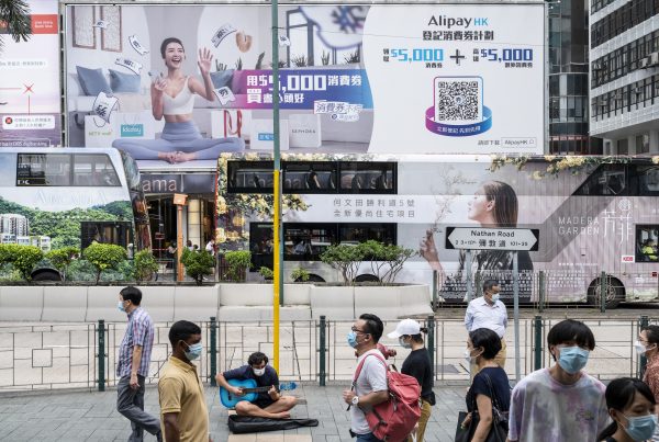 Pedestrians are seen at the foreground as a large commercial billboard ad of the Chinese online payment platform owned by Alibaba Group, Alipay is seen in the background, Hong Kong, China, 21 August 2021 (Photo: Reuters/Budru Chukrut)