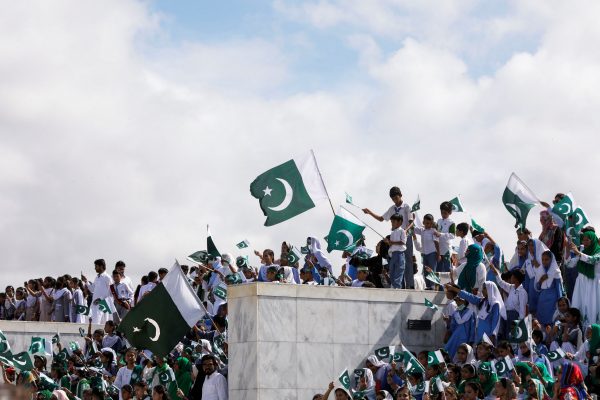 Attendees wave Pakistan's national flags during a ceremony to celebrate Pakistan's 75th Independence Day, at the Mausoleum of Muhammad Ali Jinnah in Karachi, Pakistan, 14 August 2022. (PHOTO: Akhtar Soomro via Reuters Connect)