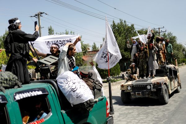 Members of the Taliban ride atop a military vehicle on the first anniversary of the withdrawal of U.S. troops from Afghanistan, on a street in Kabul, Afghanistan, 31 August 2022 (Photo: Reuters/Ali Khara).