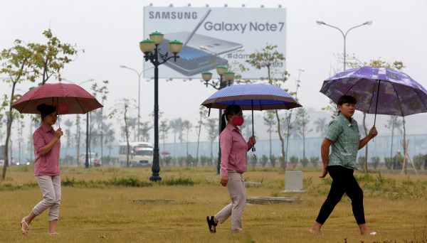 Employees pass a billboard advertisement for the Samsung Galaxy Note 7 on the way to work at the Samsung factory in Thai Nguyen province, Vietnam 13 October 2016 (Photo: Reuters/Nguyen Huy Kham)