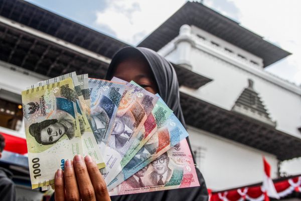 A woman displays new Indonesian banknotes in Bandung, 19 August 2022. The government of Indonesia and Bank Indonesia has launched seven new banknotes to commemorate the 77th anniversary of Indonesia's independence. (Photo: Algi Febri Sugita / SOPA Images/Sipa USA via Reuters Connect)