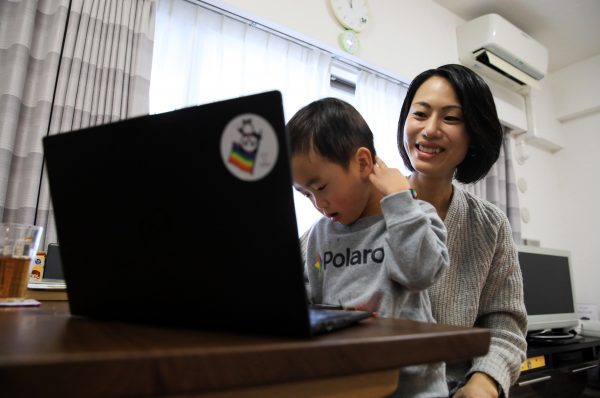 An insurance company employee performs telework while taking care of her son and daughter at home during temporary closure of school due to the spread of COVID-19 infection in Tokyo on 4 March 2020. (Photo: Reuters/The Yomiuri Shimbun)