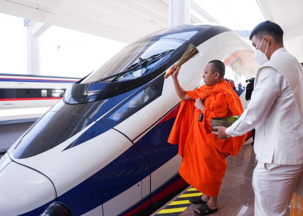 A monk blesses a train during a Buddhist ceremony one day prior to the handover ceremony of the high-speed rail project linking the Chinese southwestern city of Kunming with Vientiane, in Vientiane, Laos, 2 December 2021 (Photo: Reuters/Phoonsab Thevongsa).