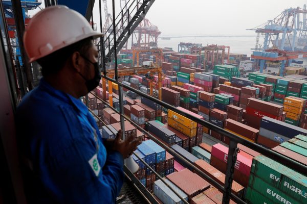 A technician stands on a crane at the Tanjung Priok port in Jakarta, Indonesia, 3 August 2022 (Photo: Reuters/Willy Kurniawan)