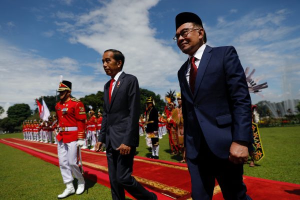 Indonesian President Joko Widodo and Malaysia's Prime Minister Anwar Ibrahim walk after inspecting the honour guards during a welcoming ceremony upon their meeting at the Presidential Palace in Bogor, Indonesia, 9 January 2023. (Photo: Reuters/Willy Kurniawan).
