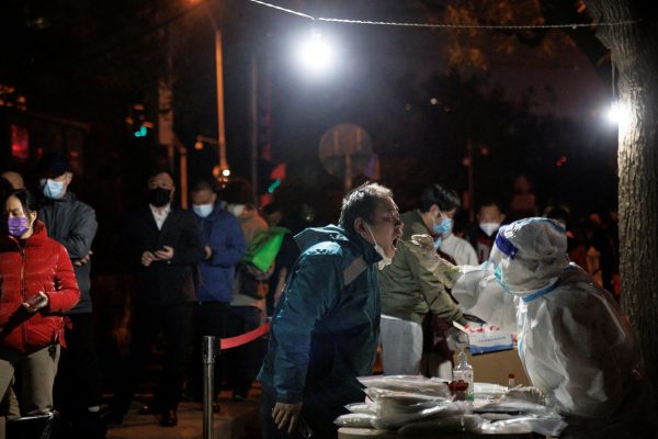 A man gets a swab tests at a temporary testing station as outbreaks of the coronavirus disease (COVID-19) continue in Beijing, China, 14 November 2022. (Photo: Reuters/Thomas Peter).