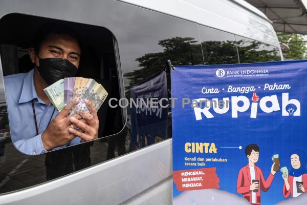 An employee on duty in a mobile money changing car shows a small amount of money that can be exchanged, Kendari, Indonesia, 25 April 2022 (Photo: Andry Denisah / SOPA Images, Sipa USA via Reuters).