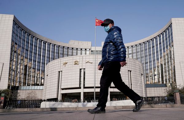 A man wearing a mask walks past the headquarters of the People's Bank of China, the central bank, in Beijing, China, 3 February 2020 (Photo: Reuters/Jason Lee/File Photo/File Photo).