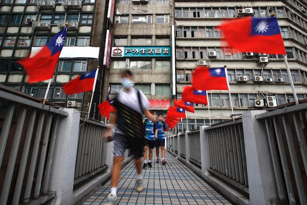 Taiwanese pupils walk across a footbridge in Taipei, where Taiwan flags flutter ahead of the island’s national day, amid rising tensions with China, in Taipei, Taiwan, on 5 October 2022 (Photo: Reuters/Ceng Shou Yi).