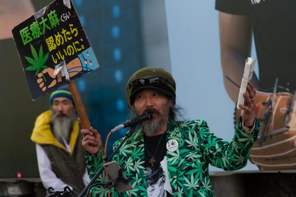 A dreadlocked Japanese man holds a placard calling for the legalisation of medical marijuana during a pro-marijuana rally by Street Cannabis Speech in Shibuya's Hachiko Square, 4 March 2023 (Photo: Damon Coulter / SOPA Images/Sipa USA via Reuters).