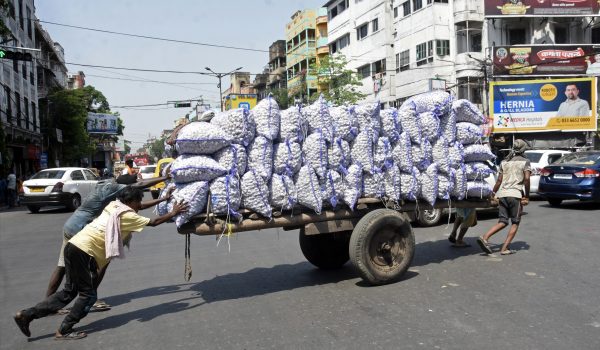Labourers pull the cart carrying bags of garlic on their way to wholesale market, in Kolkata, India, 6 April 2023 (Photo: ANI Photo via Reuters).