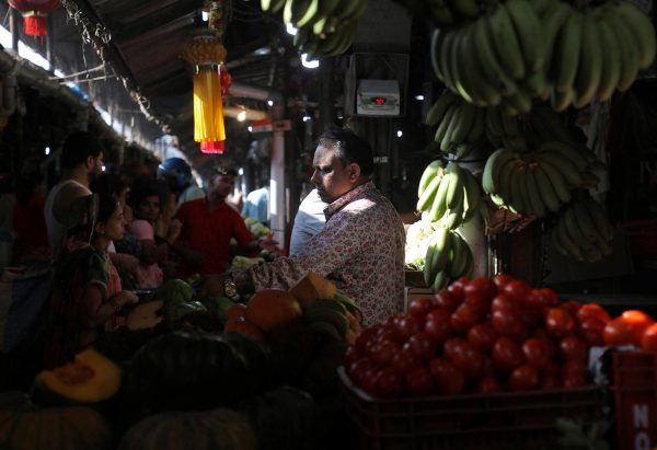 A fruit vendor tends to customers at a fruit and vegetable wholesale market in Mumbai, India, 8 February, 2023 (Photo: Reuters/Niharika Kulkarni).