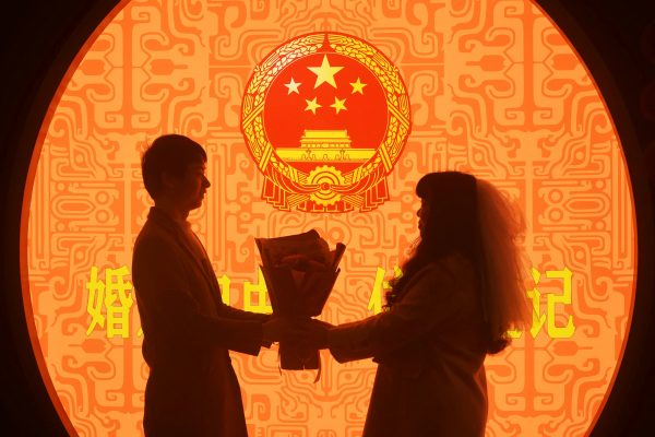 A newly wed couple pose for pictures on Valentine's Day at a marriage registration office in Hangzhou, Zhejiang province, China 14 February 2023 (Photo: Reuters/China Daily).